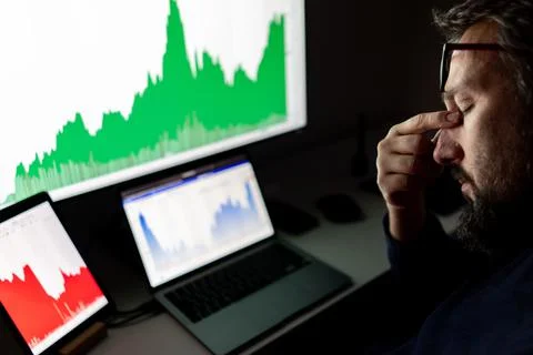 Depressed businessman in front of computer with graph of unsuccessful business Stock-Fotos