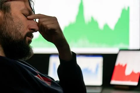 Depressed businessman in front of computer with graph of unsuccessful business Stock-Fotos