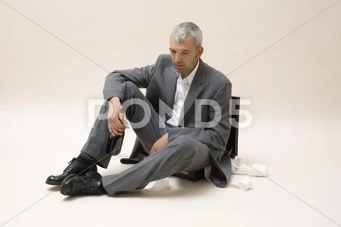 A depressed businessman holding a bottle of wine Stock Photos