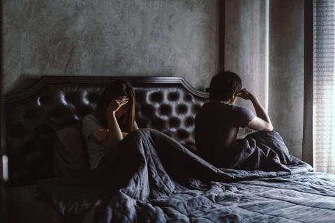 Depressed couple having problem sitting head in hands in the derk bedroom at  Fotos Stock
