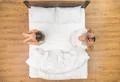 The depressed couple hold head on the bed. view from above Photo