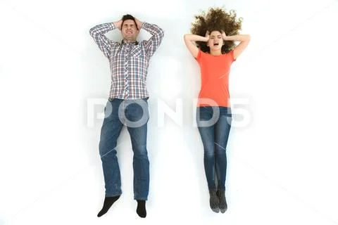 The depressed couple lay on the white floor. View from above Stock Photos
