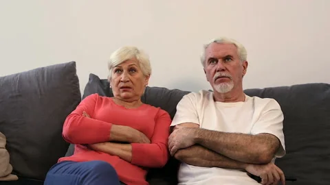Depressed elder couple sitting on the sofa and watching tv. No emotions. Stock-Footage 102569213