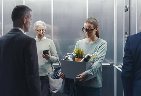 Depressed fired woman standing in the elevator 스톡 사진