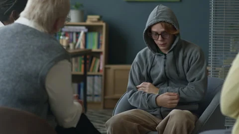 Depressed Gen Z Boy Avoiding Eye Contact during Group Therapy Stock Footage 317830091