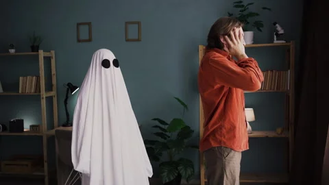 Depressed man grieving over loss of loved one standing at window ghost of his Stock Footage 314070488