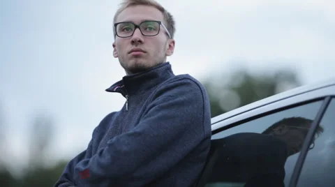 Depressed man in jacket and glasses near the car Stock Footage 55334683