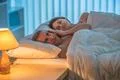 The depressed man lie with woman on the bed. Evening night time Photo