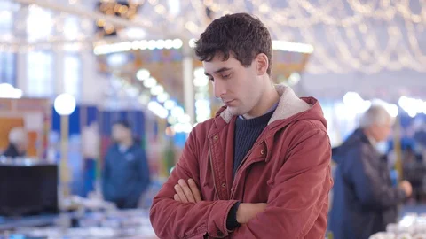 Depressed man looking down in a shopping center at christmas time Video stock 129591245
