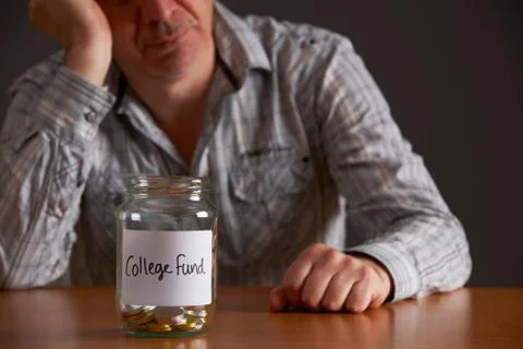 Depressed Man Looking At Empty Jar Labelled College Fund Stock Photos