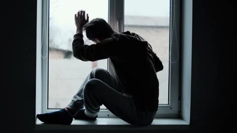 Depressed man looking out the window. Depression or sadness. Guy knocking on the Stock Footage 297462580
