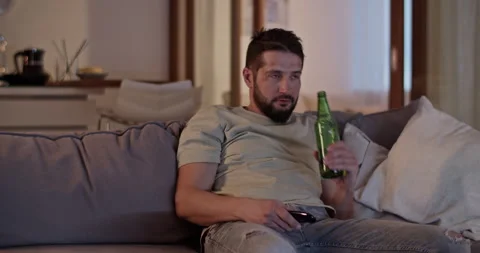Depressed man lying on sofa and using remote control Stock Footage 271160863