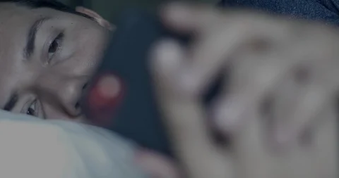 Depressed Man Scrolls through Phone Before Bed Sleepless Tired Concept Stock Footage 114701571