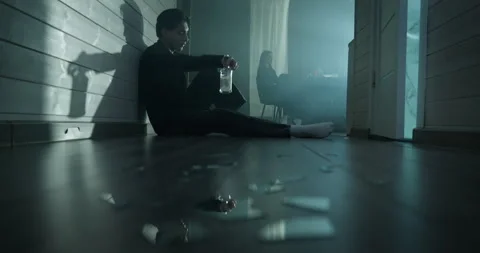 Depressed man sit floor drink bottle alcohol, angry woman ignore. Vidéo 337993396