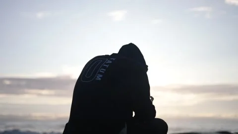 Depressed man sits before sunset Stock Footage 196268148