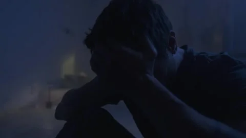 Depressed man sitting alone in dark bedroom, emotional burnout and despair Stock Footage 320186932
