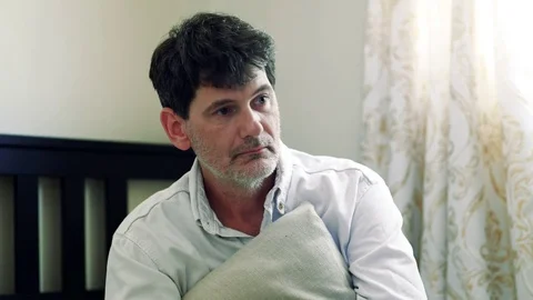 Depressed man sitting on bed Stock Footage 77301757