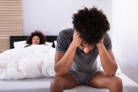 Depressed Man Sitting On Bed Stock Photos