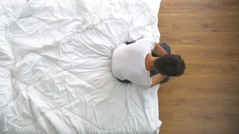 The depressed man sitting on the bed. view from above Stock Footage 90041003
