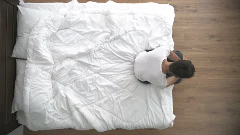 The depressed man sitting on the bed. view from above Stock Footage 90090042
