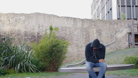 Depressed man sitting on a carousel as it turns around Stock Footage 115077702