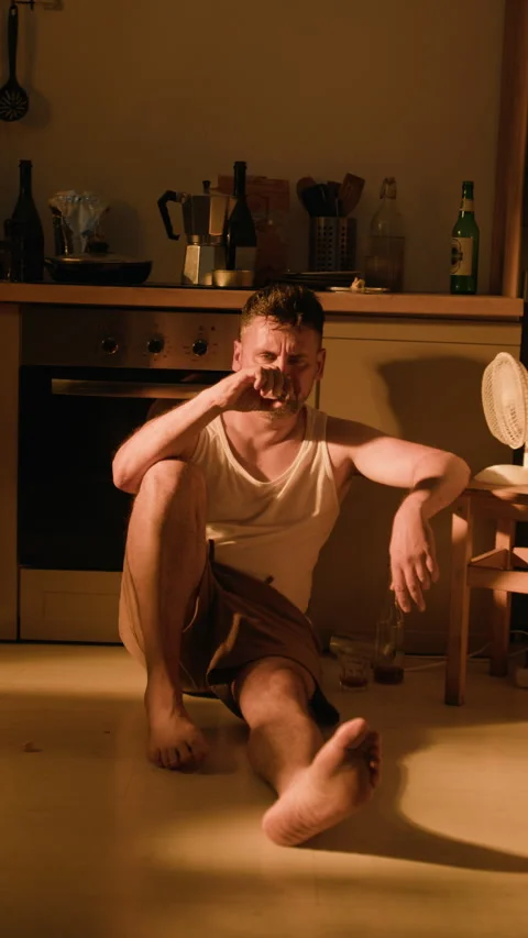 Depressed Man Sitting on Floor Suffering from Alcohol Addiction Stock Footage 344861795