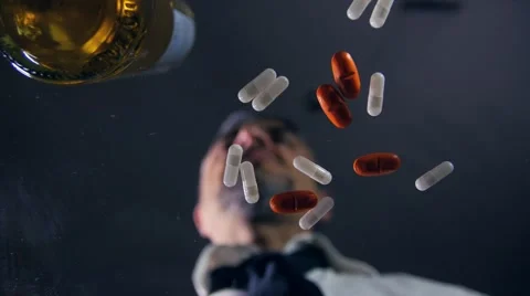 Depressed man taking pills drinking alcohol Vidéo 50672266