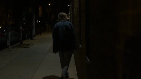 Depressed Man Walks Down Sidewalk at Night Stock Footage 121594711