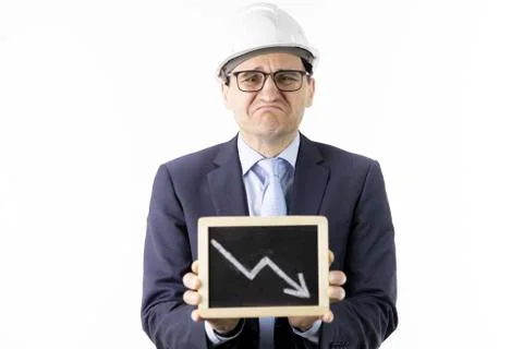 Depressed mining engineer holds tablet with down arrow declining oil quotes Stock Photos