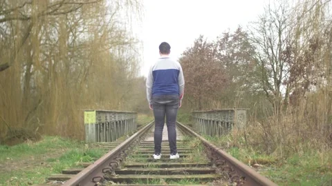 Depressed School Boy Standing on Train Tracks Stock Footage 148274331