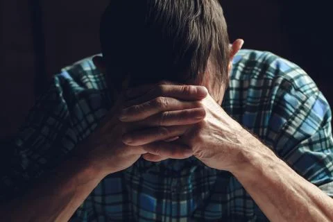 Depressed senior covers his face with his hands. Alzheimer's dis Stock Photos