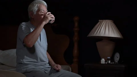 Depressed senior man cannot sleep from insomnia and taking medication Stock Footage 146204011