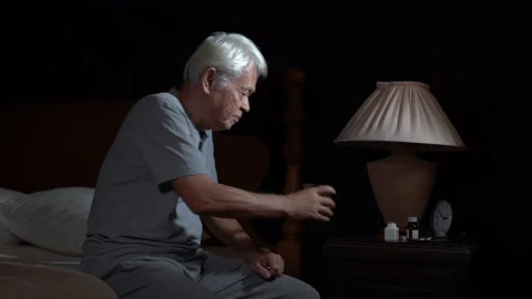 Depressed senior person cannot sleep from insomnia and taking medication Stock Footage 130929657