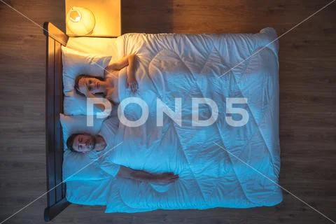 The depressed woman lay on the bed. evening night time. view from above Stock Photos