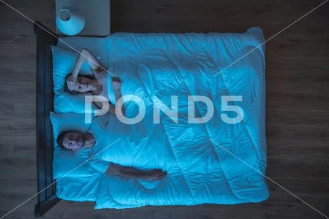 The depressed woman lay on the bed. evening night time. view from above Stock Photos