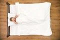 The depressed woman lay on the bed. View from above Photo