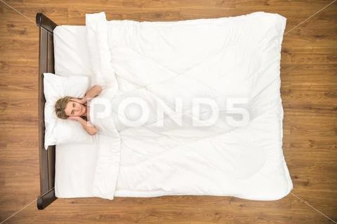 The depressed woman lay on the bed. View from above Stock Photos