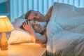 The depressed woman lay with man on the bed. Evening night time Photo