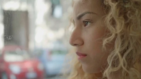 Depressed woman looking out from a bus window: slow motion side portrait Stock Footage