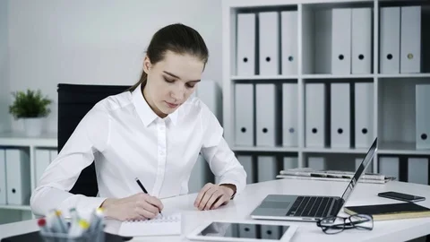 Depressed woman at workplace making notes. 库存影片 72896872