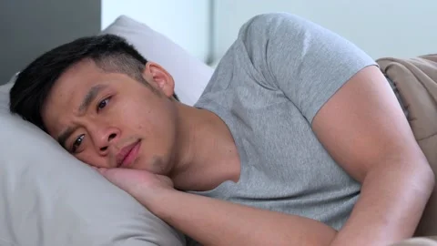 Depressed young Asian man cannot sleep from insomnia Stockbeeldmateriaal 156638031