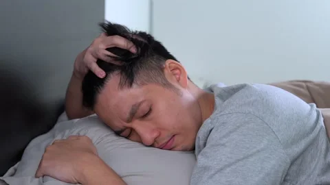 Depressed young Asian man cannot sleep from insomnia Stockbeeldmateriaal 156638246