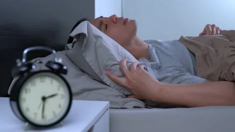 Depressed young Asian man cannot sleep from insomnia Stockbeeldmateriaal 156638279