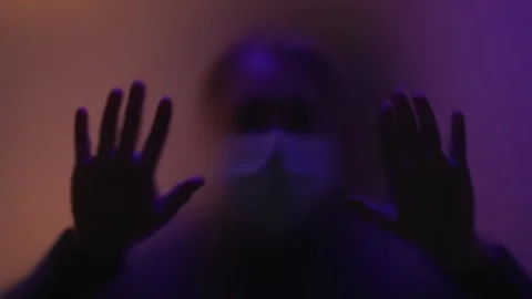 Depression concept.image of man in mask and silhouette of hands behind glass Stock Footage 260806210