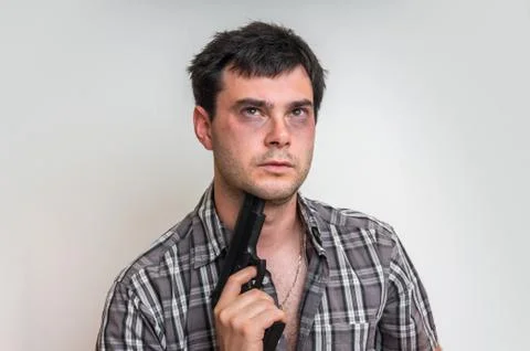 Depressive man trying to commit suicide with a gun aiming on his head Stock Photos