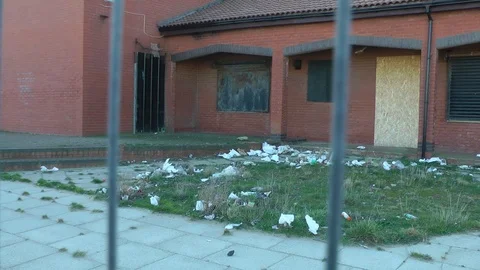 Derelect boarded up with litter on grass 動画素材 104311168