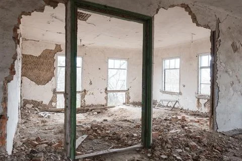 Derelict interior space featuring collapsed plaster, exposed brickwork, debri Stock Photos