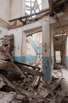 Derelict structure interior showing collapsed ceiling beams, scattered rubble Stock Photos