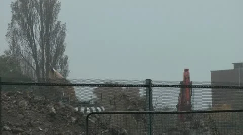 Derelict tower block, a 360 digger spins as it clears rubble Stock Footage 14769400