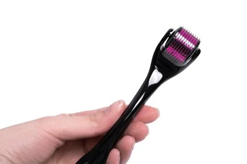Derma roller isolated on a white background. Woman holds in hand device for c Stock Photos
